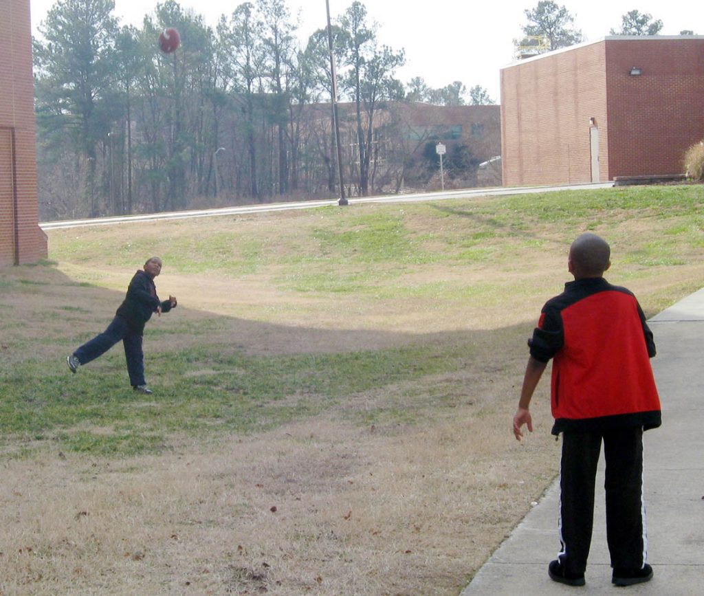 Outside the gym, boys toss around their new football – a holiday tradition. 