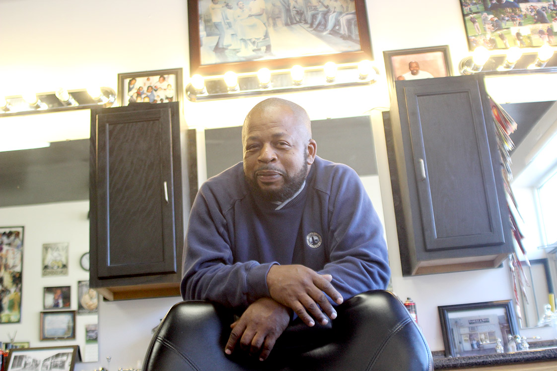 Samuel, at the single chair, in his rebuilt barber shop on Angier Ave.: Never give up," he says. (Staff photo by Jamar Negron)