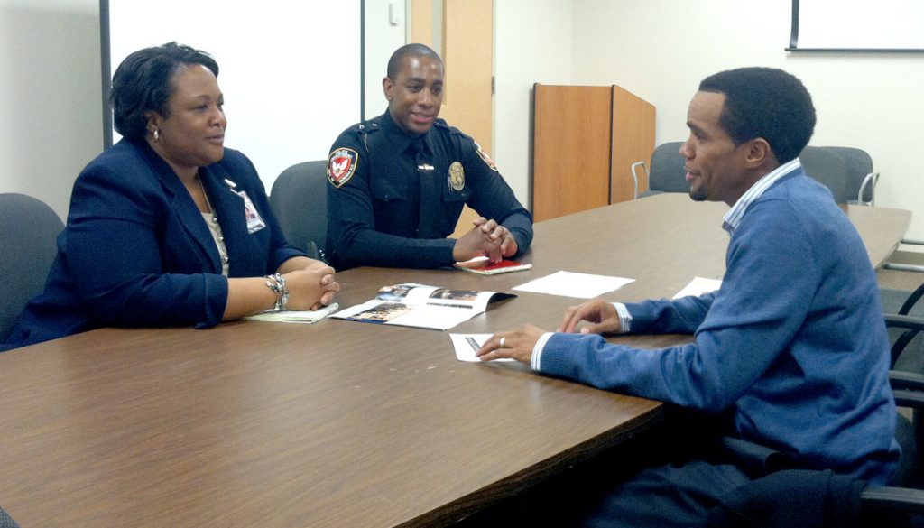     Evit Blackmon, right, meets with Kimberle Walker and Curtis Knight at the DPD Substation on Holloway Drive. Due to restricted resources, Knight is the only community resource officer for Blackmon’s district.     Staff photo by Zach Potter