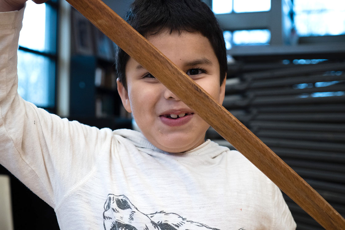 Adonis Lión, a student in Bennett’s class, holds his sword up high while listening to Bennett. (Staff photo by Cole McCauley)